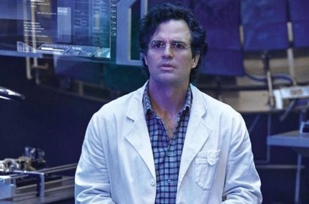 Bruce Banner wears a lab coat in top of checkered shirt.